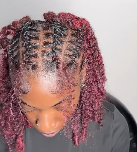 Twists/loc style with red hair color and clean parts.